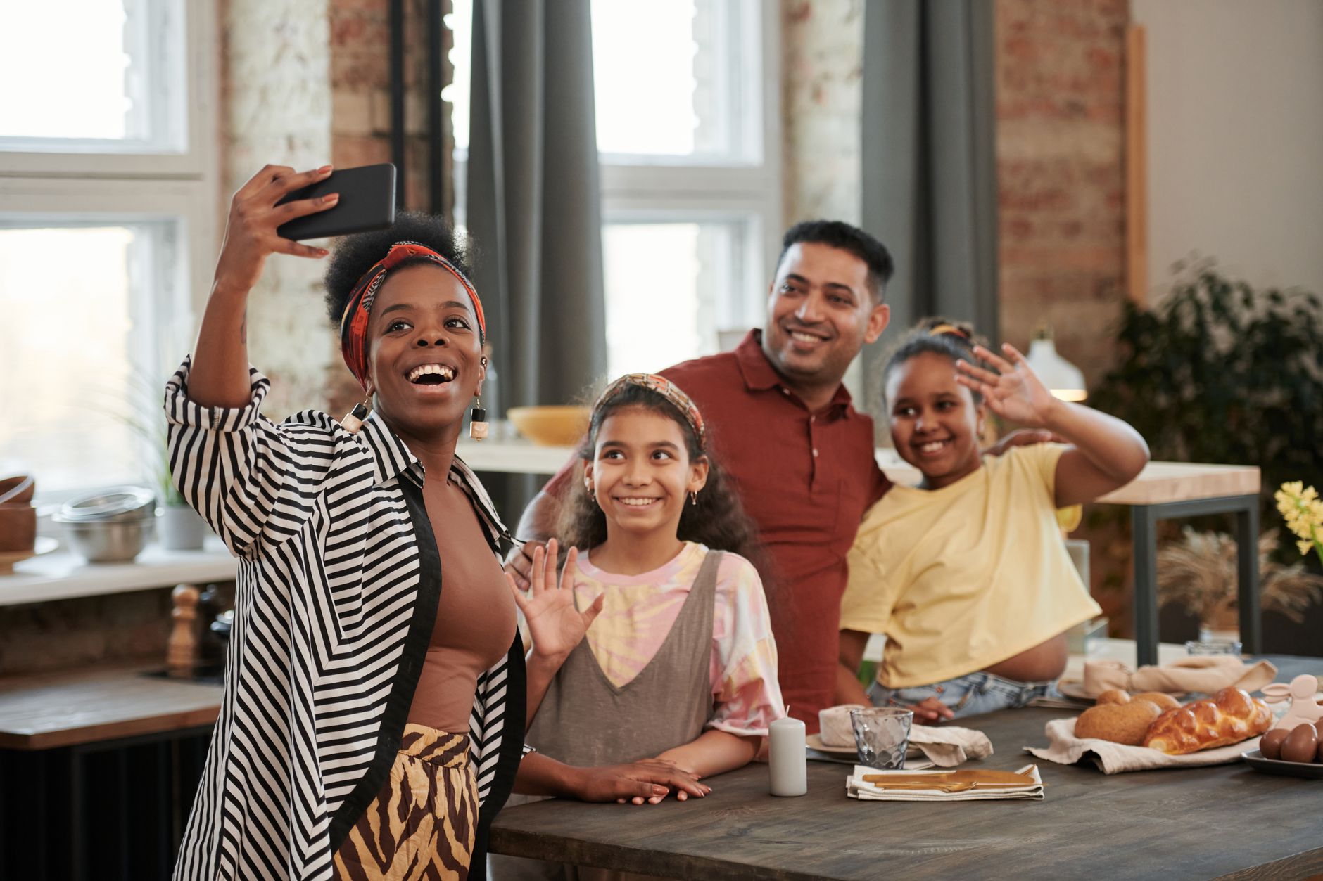 A family at a kitchen table pointing at a written code phrase while one person holds a phone.