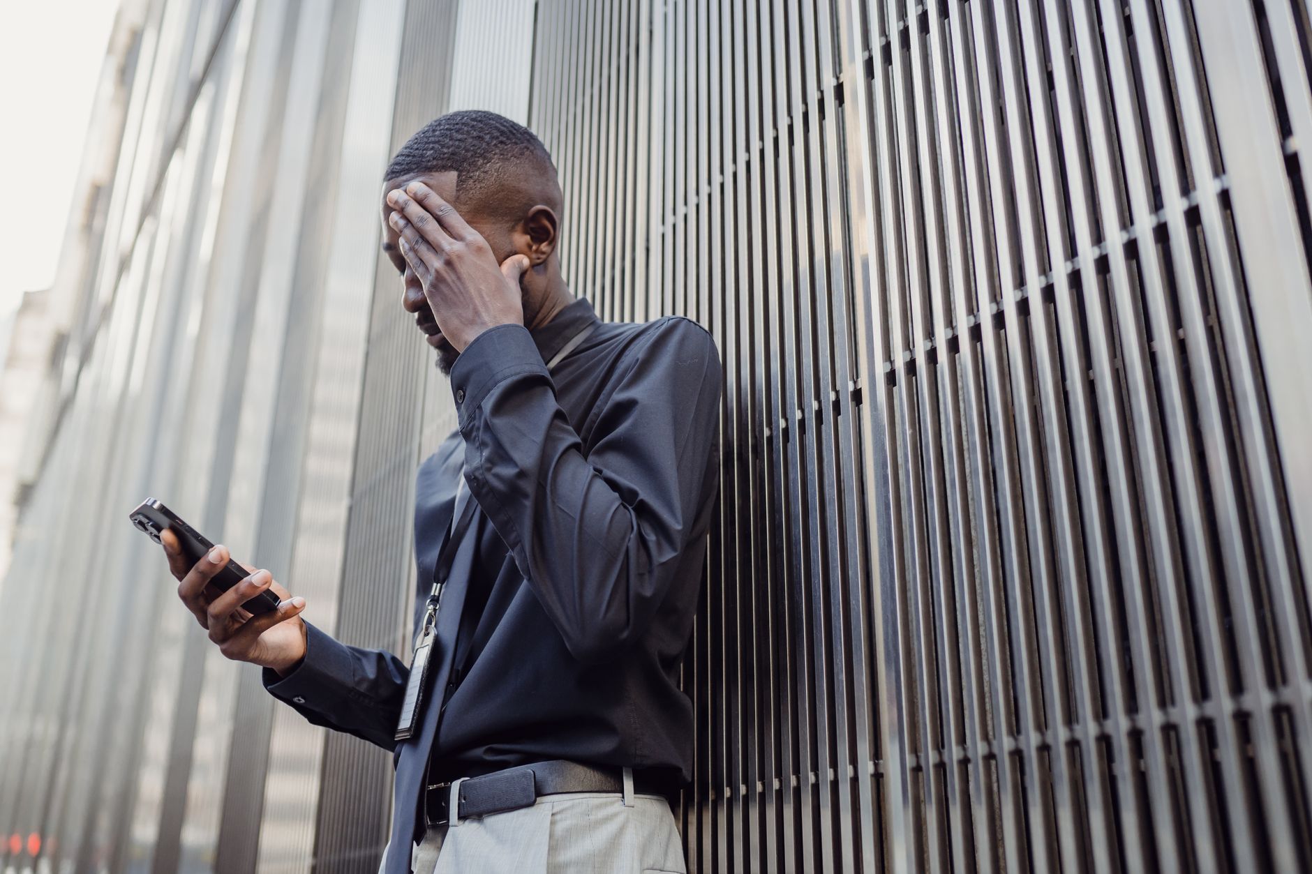 A person holds a smartphone to their ear while frowning with concern during a phone call.
